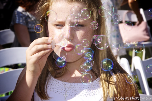 Flower girl bubble blowing - wedding photography